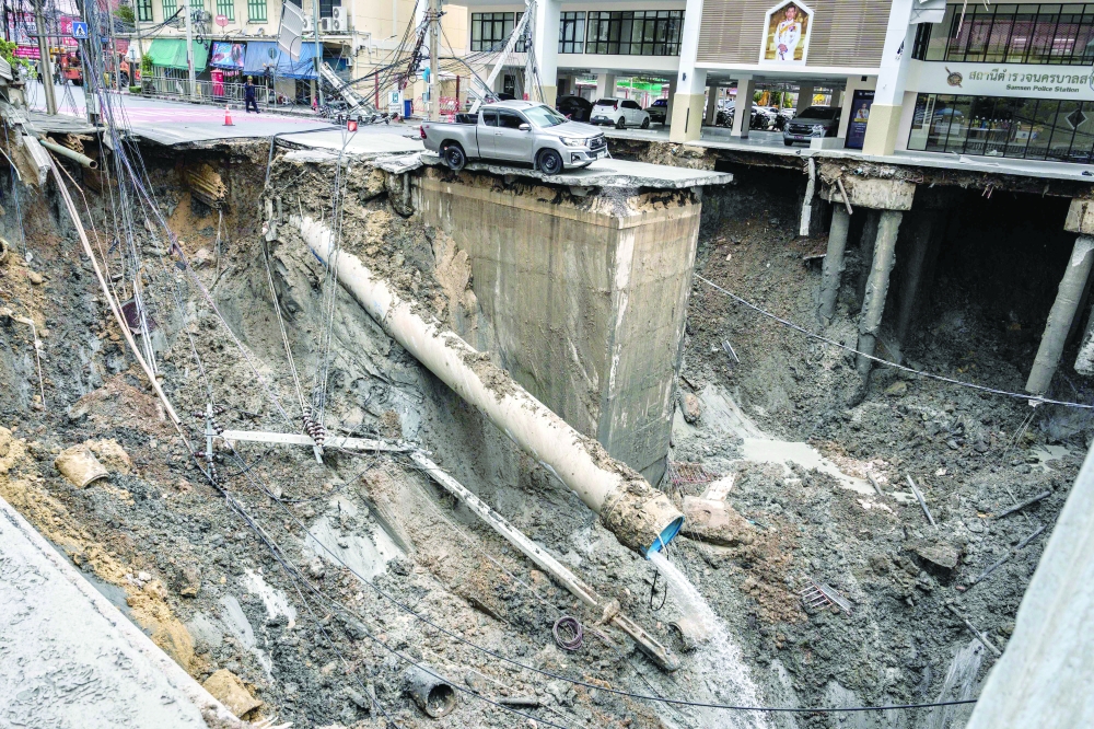 A vehicle is seen on the edge of a hole 