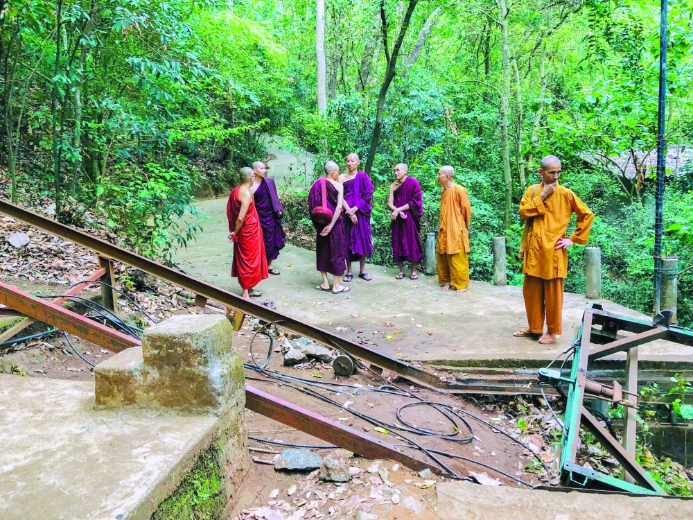 Buddhist monks stand at the site of a cable car accident in Sri Lanka's north-western district of Kurunegala. - AFP