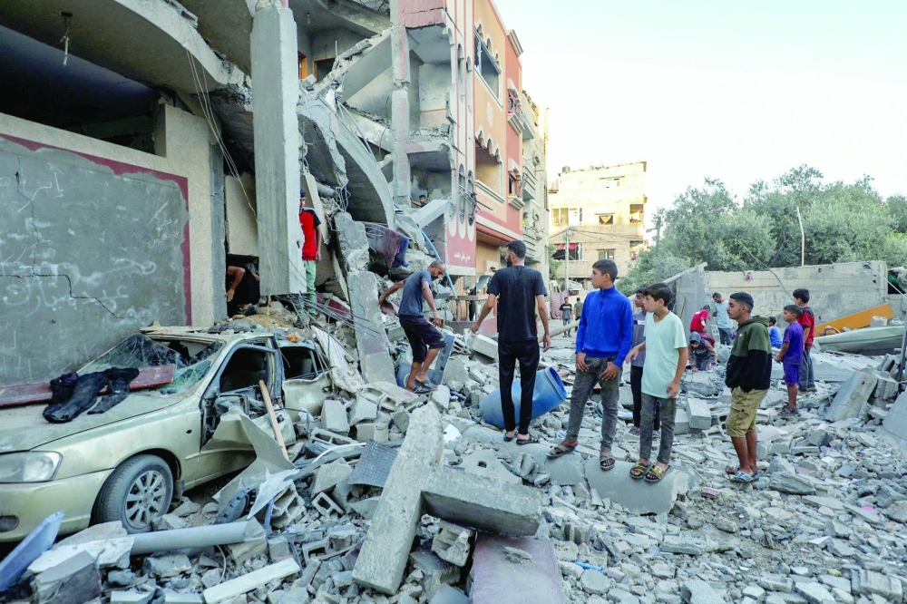 Palestinians check the rubble of buildings hit by an Israeli strike in the Nuseirat refugee camp in the central Gaza Strip. - AFP