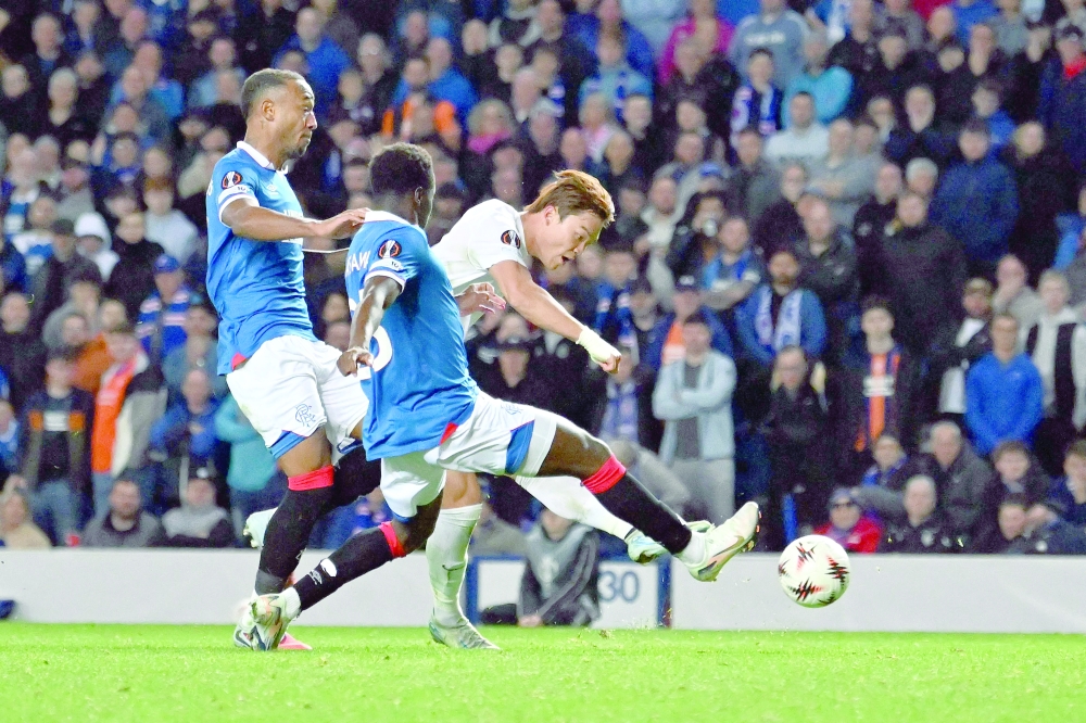 KRC Genk's South Korean striker #09 Hyeon-Gyu Oh (R) scores the opening goal during the UEFA Europa League, league stage football match between Rangers and Genk at the Ibrox Stadium in Glasgow on September 25, 2025. (Photo by ANDY BUCHANAN / AFP)
