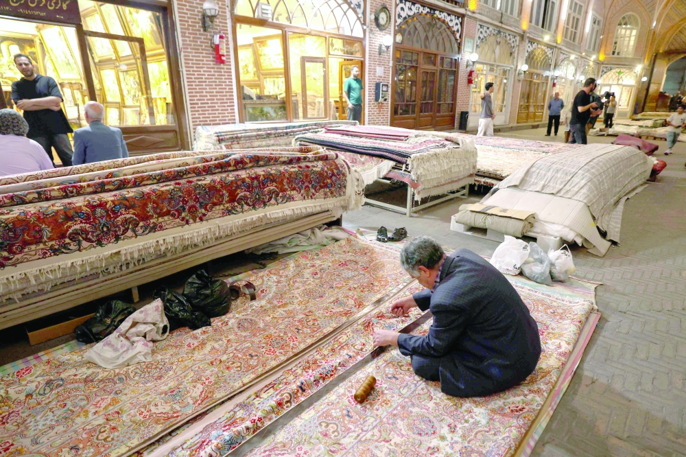 A man restores a carpet in Tabriz's historic market, believed to be one of the oldest bazaars in the Middle East, in northwestern Iran, on September 17, 2025. (Photo by ATTA KENARE / AFP)