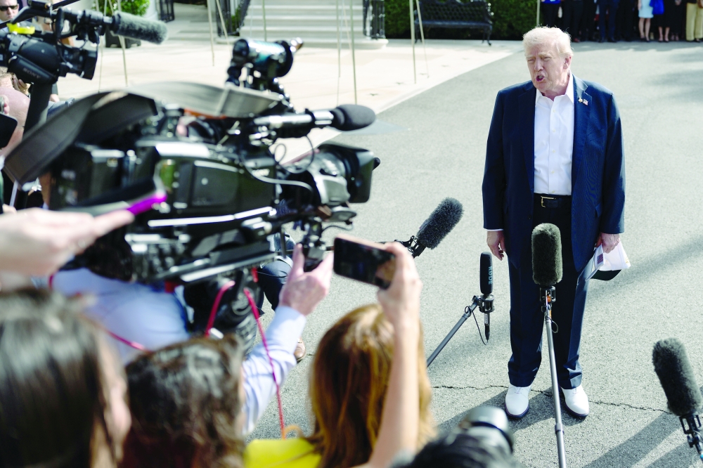 President Donald Trump speaks to reporters while leaving the White House. 