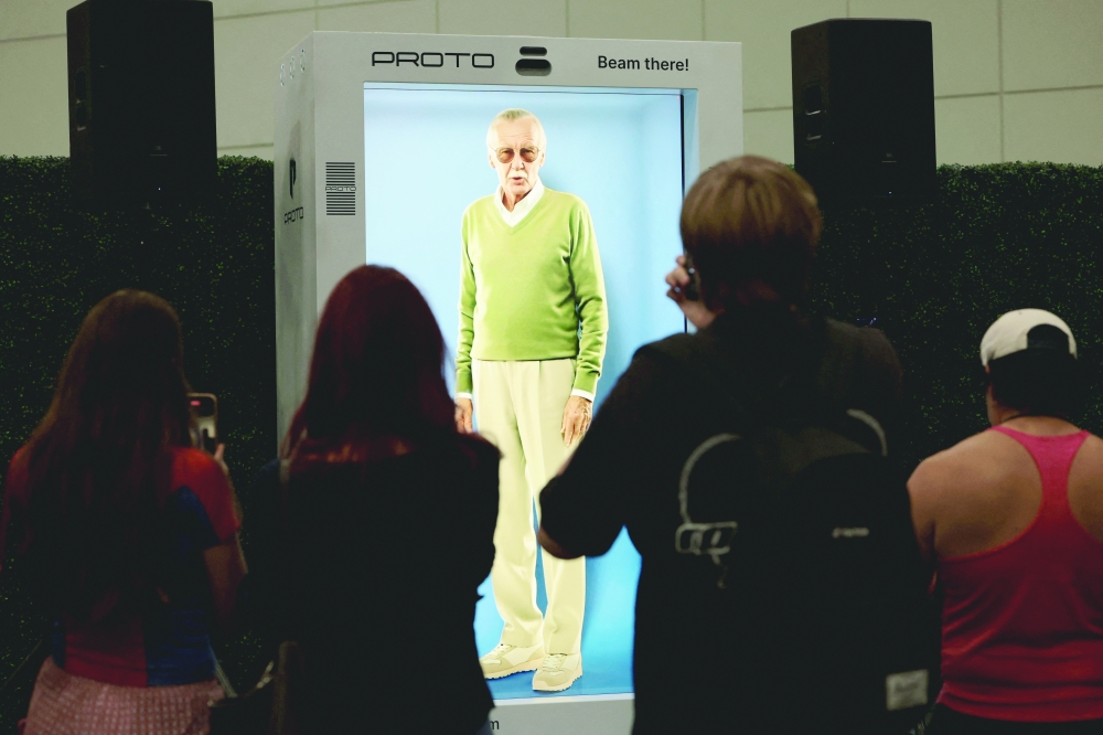 Attendees interact with an AI hologram of comic book writer Stan Lee projected into a Proto Epic device during L.A. Comic Con in Los Angeles, California, U.S., September 26, 2025. REUTERS/Mario Anzuoni