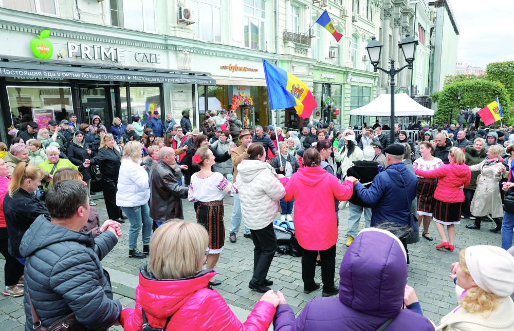 People dance as they queue outside a polling a station located in the embassy of Moldova, in Moscow. — Reuters 