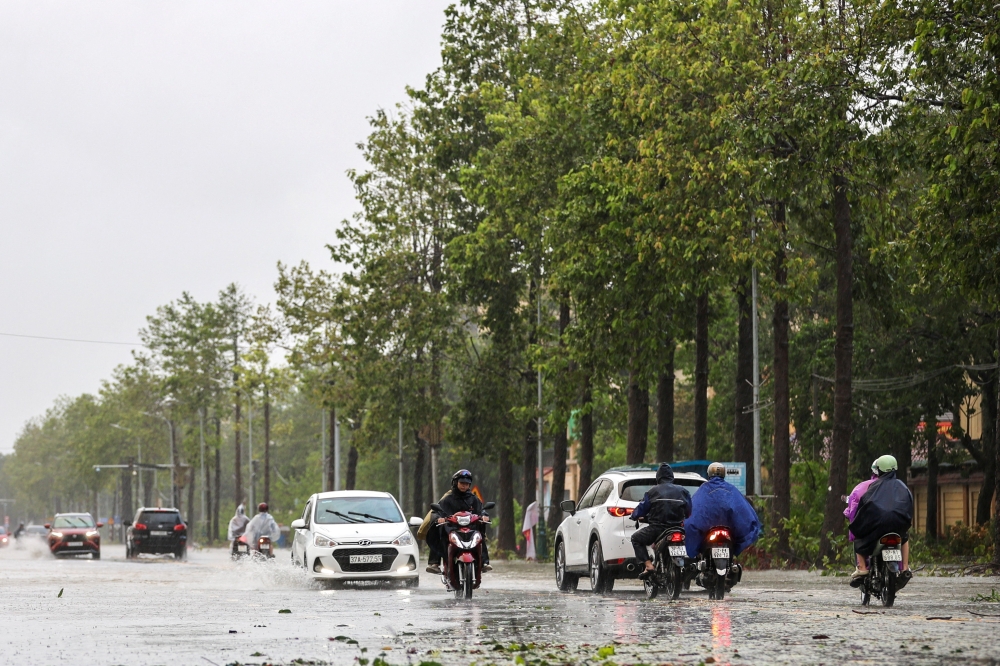 People commute on a flooded street after Typhoon Bualoi makes landfall in Nghe An province, Vietnam, September 29, 2025.