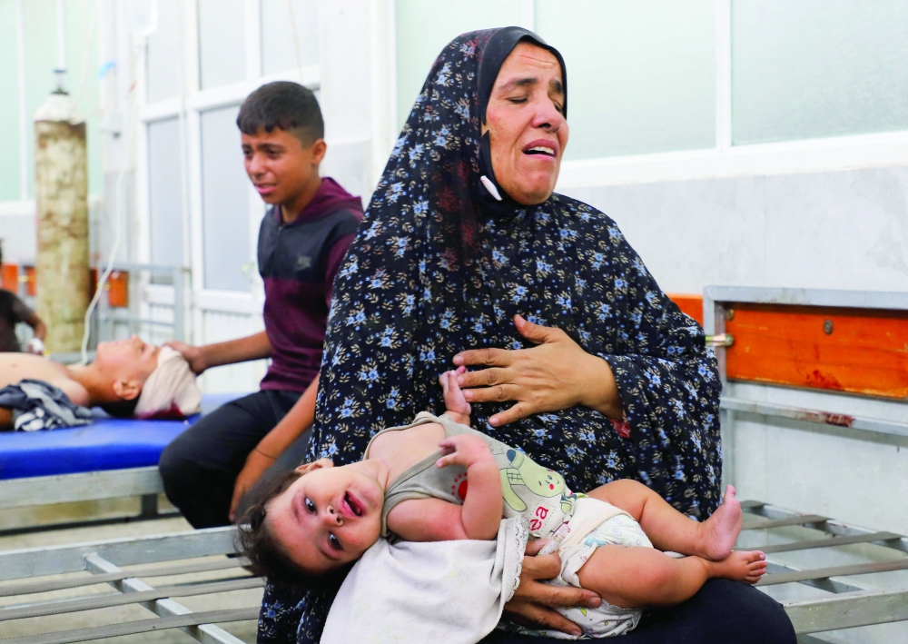 Wounded Palestinians receive treatment at Al Shifa Hospital after being injured in an Israeli strike in Gaza City on Monday. — Reuters
