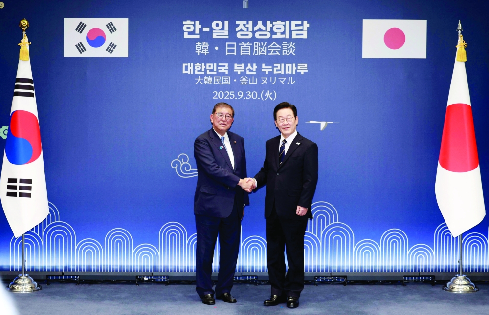 Japanese PM Shigeru Ishiba (L) shakes hands with South Korean President Lee Jae Myung (R) at Nurimaru APEC House in Busan. — AFP