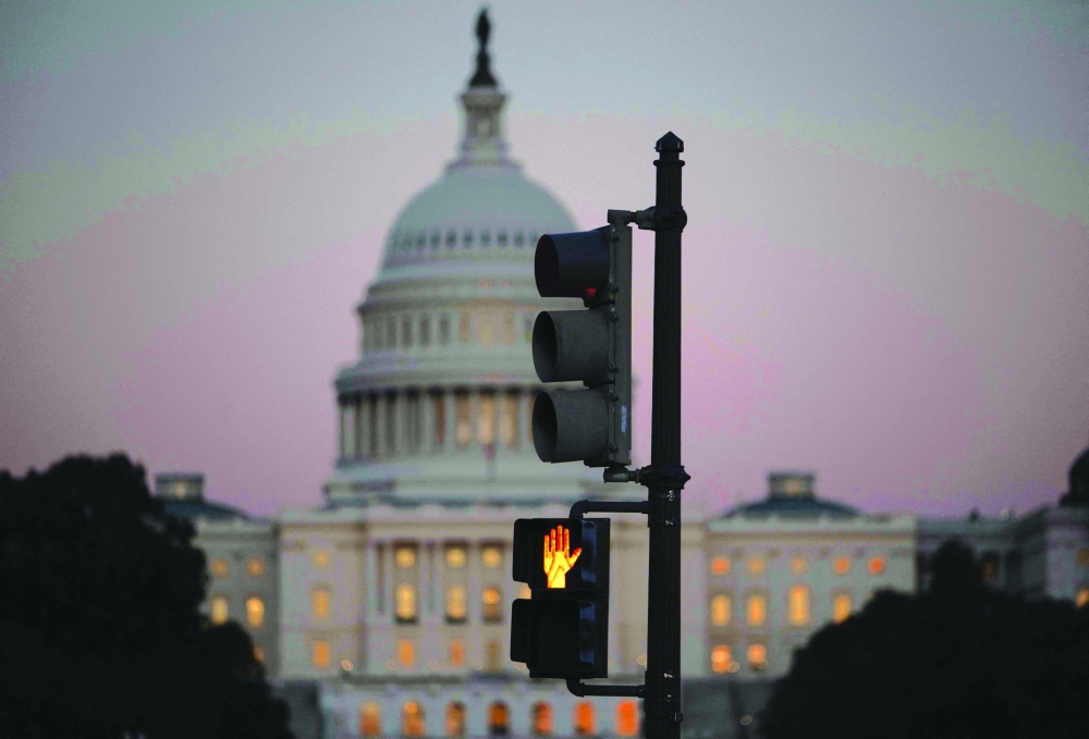  crosswalk signal of a traffic light flashes backdropped by the US Capitol in Washington, DC