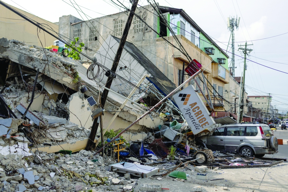 A vehicle partially buried under rubble amid destruction caused by the magnitude 6.9 quake in Bogo, Cebu, Philippines. - Reuters
