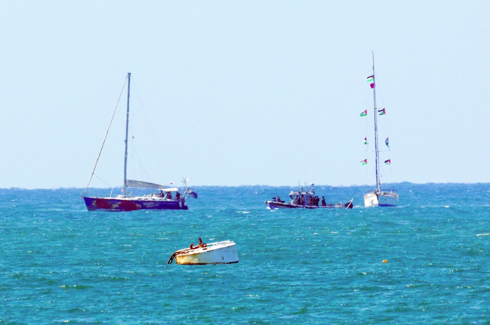 An Israeli navy vessel escorts vessels from the Global Sumud Flotilla to Ashdod Port in southern Israel. - Reuters