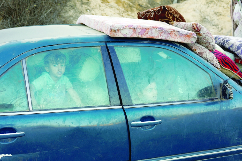 Displaced Palestinians, who fled northern Gaza after Israeli forces ordered residents of Gaza City to evacuate sit inside a car that broke down in the central Gaza Strip. — Reuters