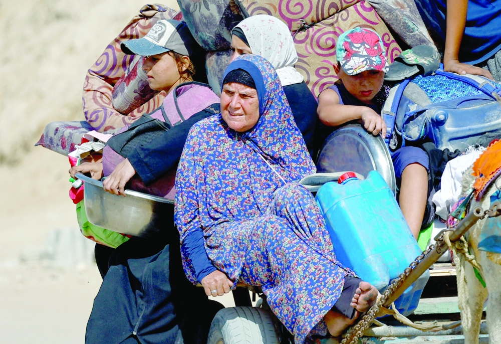 Displaced Palestinians, fleeing northern Gaza due to an Israeli military operation, ride a vehicle pulled by an animal as they move southwards following Israeli forces' orders to leave Gaza City on Friday. — Reuters