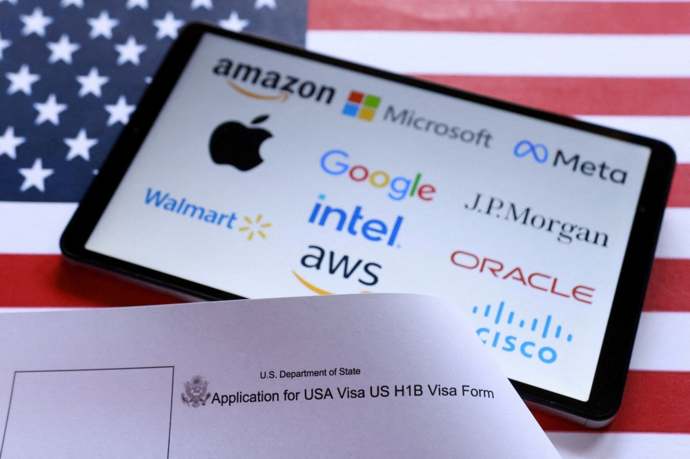 U.S. flag, H-1B visa application form, and displayed company logos are seen in this illustration taken September 26, 2025. REUTERS/Dado Ruvic/Illustration/File Photo