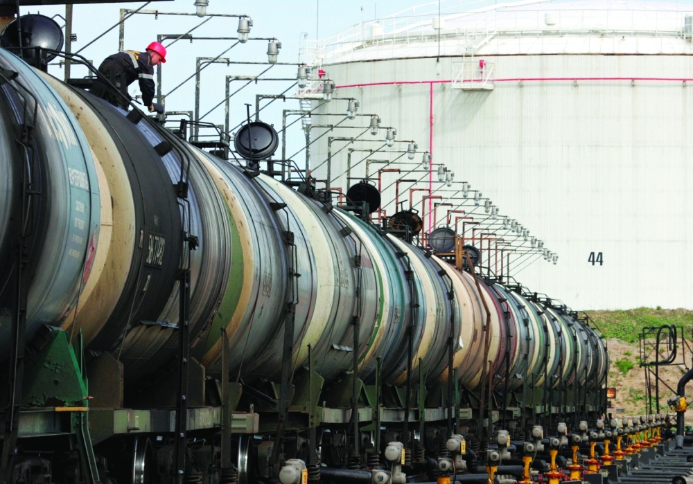 A worker controls the freight level of a tanker wagon at the Rosneft oil terminal in Arkhangelsk