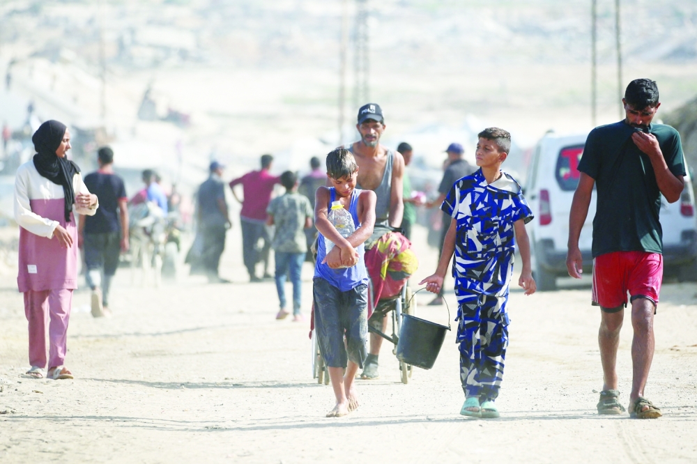 Palestinians walk on a coastal path northwest of Nuseirat refugee camp. — AFP