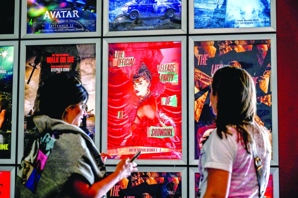Fans take pictures in the lobby as they attend "Taylor Swift: The Official Release Party of a Showgirl" at AMC Montgomery 16 movie theater in Bethesda, Maryland on October 3, 2025.  With friendship bracelets on their wrists and feathers in their hair, fans attend the October 3 screening of the film about Taylor Swift痴 new album, "The Life of a Showgirl". Beyond the singer痴 personal commentary, the feature allows fans to watch the video for the album's first track, "The Fate of Ophelia," and to sing and dance together in cinemas預 moment of communion for enthusiasts who form a close-knit community. "For Taylor Swift, it痴 not just about selling tickets, but also offering her fans a place to gather, celebrate and share the musical experience," a branding expert said. "This three-day limited screening also allows her to premiere new videos and share behind-the-scenes commentary, giving fans a sense of exclusive access." (Photo by Alex WROBLEWSKI / AFP)