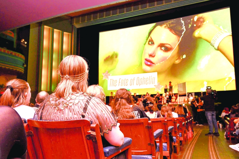 TOPSHOT - Taylor Swift fans listen to a song during a listening event for Swift's new album 'The Life of a Showgirl' at the Astor Theatre in Melbourne on October 3, 2025. Swift on October 3 dropped her 12th studio album, "The Life of a Showgirl," a collection of bouncy pop songs about love, marriage, success -- and score-settling. For the hotly anticipated album, the 35-year-old artist reunited with Swedish hitmakers Max Martin and Shellback, and their influence is clear in the driving beats and catchy hooks. (Photo by William WEST / AFP)