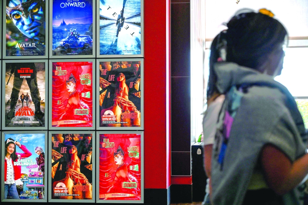 Fans walk by Swift posters as they arrive to "Taylor Swift: The Official Release Party of a Showgirl" at AMC Montgomery 16 movie theater in Bethesda, Maryland on October 3, 2025.  With friendship bracelets on their wrists and feathers in their hair, fans attend the October 3 screening of the film about Taylor Swift痴 new album, "The Life of a Showgirl". Beyond the singer痴 personal commentary, the feature allows fans to watch the video for the album's first track, "The Fate of Ophelia," and to sing and dance together in cinemas預 moment of communion for enthusiasts who form a close-knit community. "For Taylor Swift, it痴 not just about selling tickets, but also offering her fans a place to gather, celebrate and share the musical experience," a branding expert said. "This three-day limited screening also allows her to premiere new videos and share behind-the-scenes commentary, giving fans a sense of exclusive access." (Photo by Alex WROBLEWSKI / AFP)