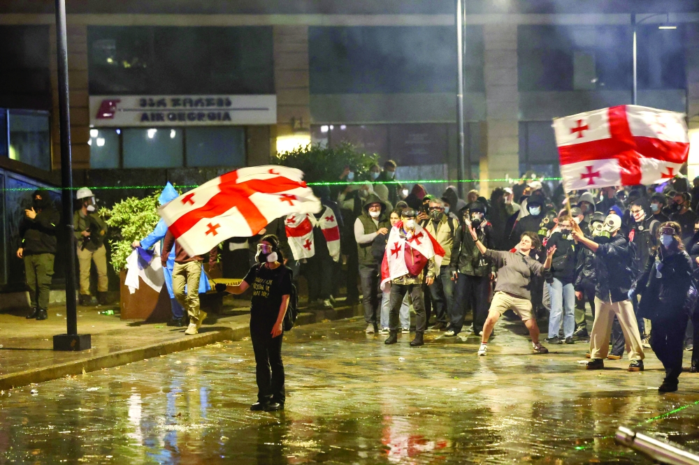 Protesters face riot police during an opposition rally on the day of local elections in central Tbilisi. — AFP