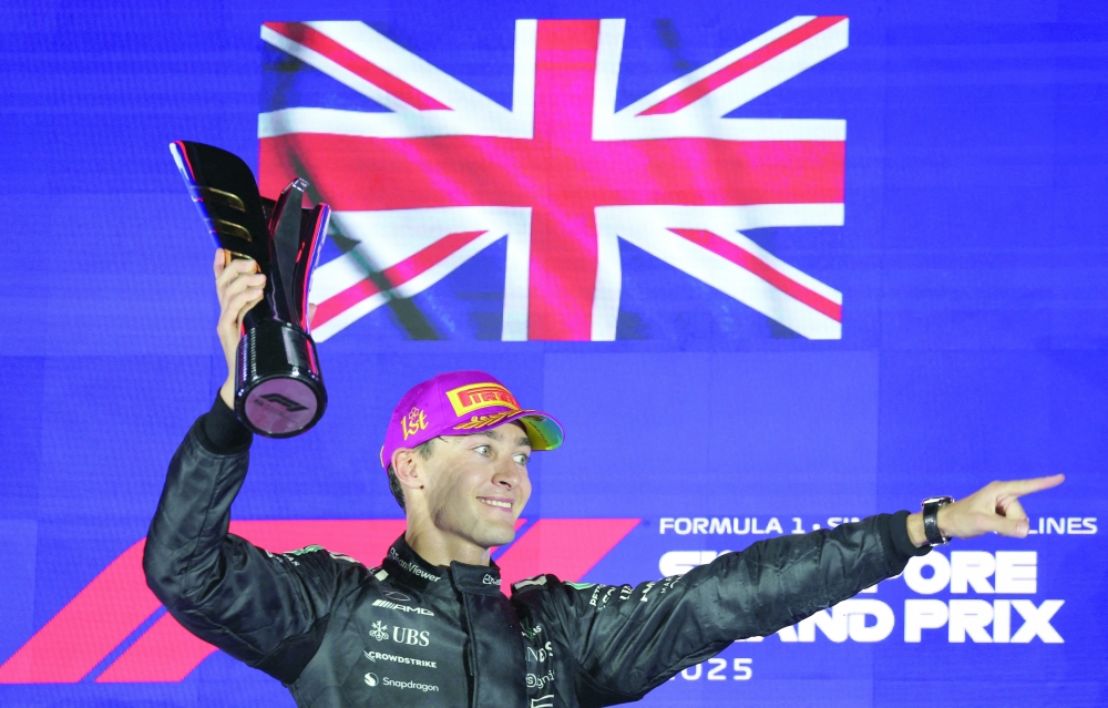 Mercedes' George Russell celebrates on the podium with the trophy after winning the Singapore Grand Prix. — Reuters