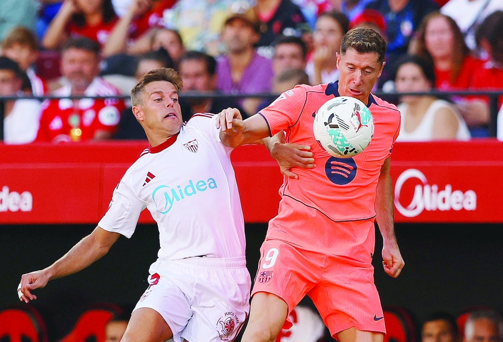 Soccer Football - LaLiga - Sevilla v FC Barcelona - Ramon Sanchez Pizjuan, Seville, Spain - October 5, 2025 Sevilla's Cesar Azpilicueta in action with FC Barcelona's Robert Lewandowski REUTERS/Marcelo Del Pozo