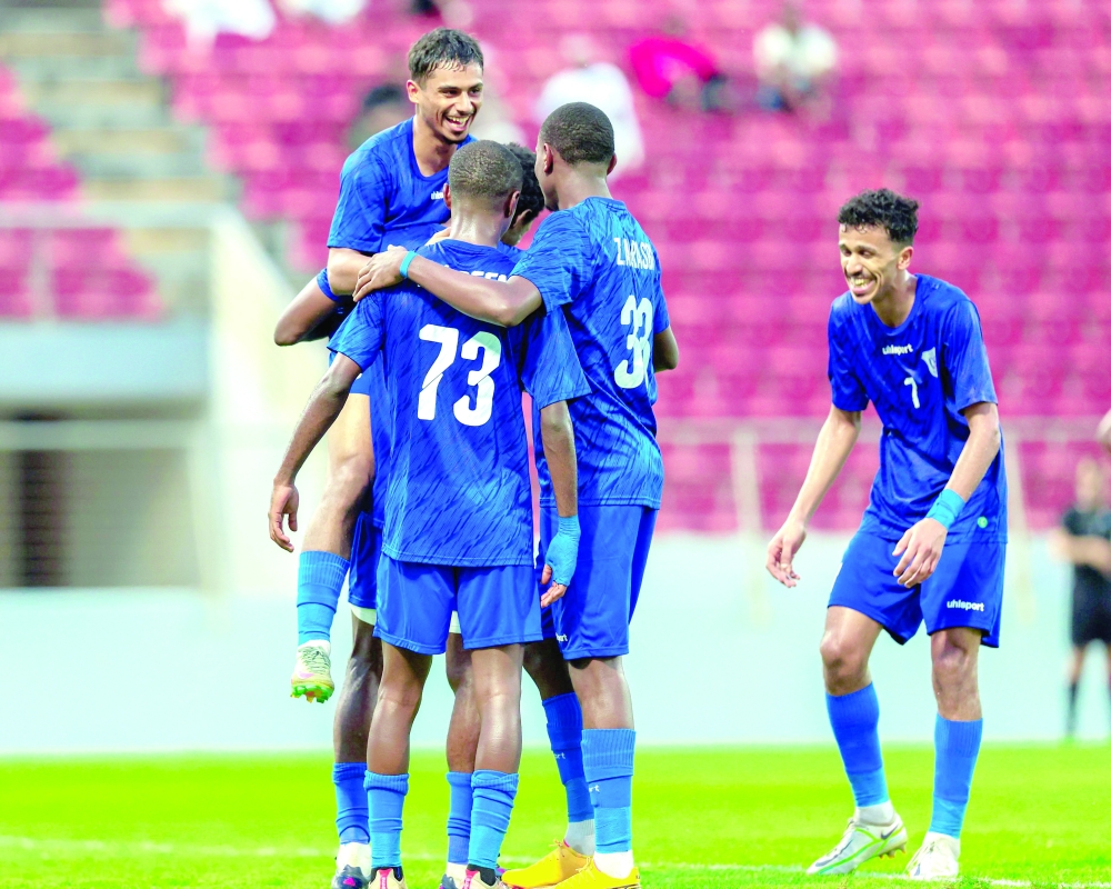 Al Nasr players celebrate scoring a goal. 