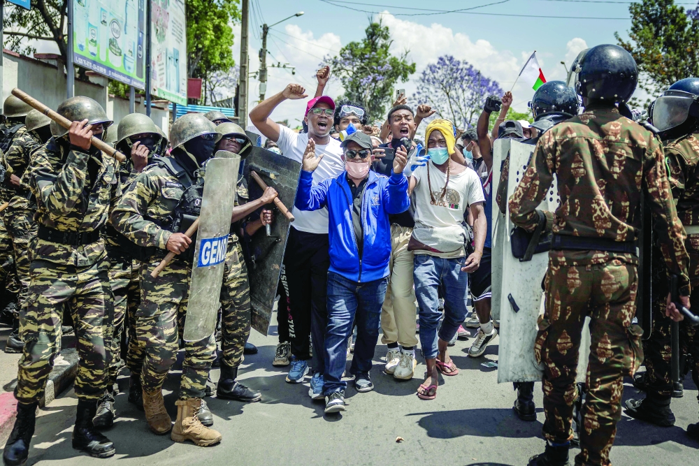 Protesters react as they breach a Malagasy gendarmerie formation during clashes, in Antananarivo. — AFP