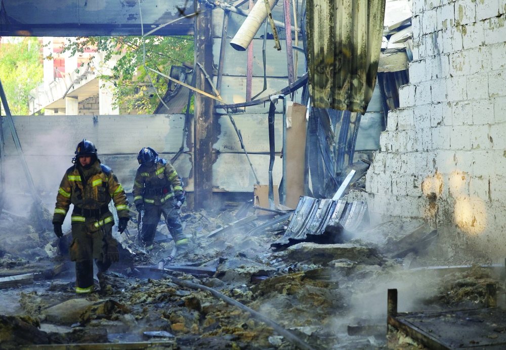 Firefighters work inside the burned-out Sigma shopping mall, in Donetsk, Ukraine. — Reuters