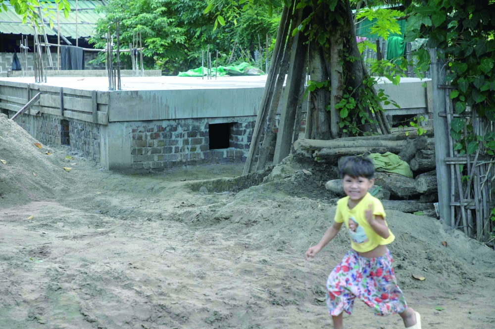 A child playing next to a concrete bunker used as a classroom to protect against air strikes at a village in the Sagaing region. - AFP