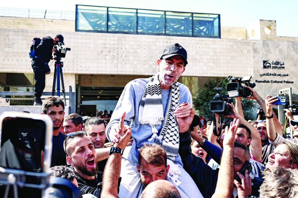 A freed Palestinian is carried on shoulders upon arrival by bus at Ramallah Cultural Centre. — AFP