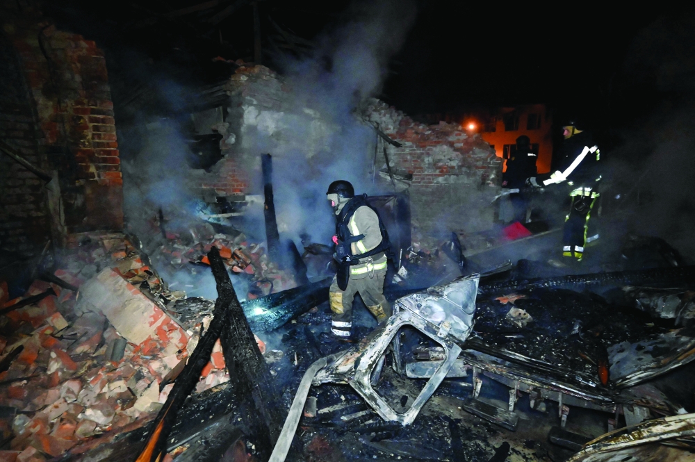 Ukrainian firefighters work to extinguish a smouldering building, in Kharkiv. — AFP