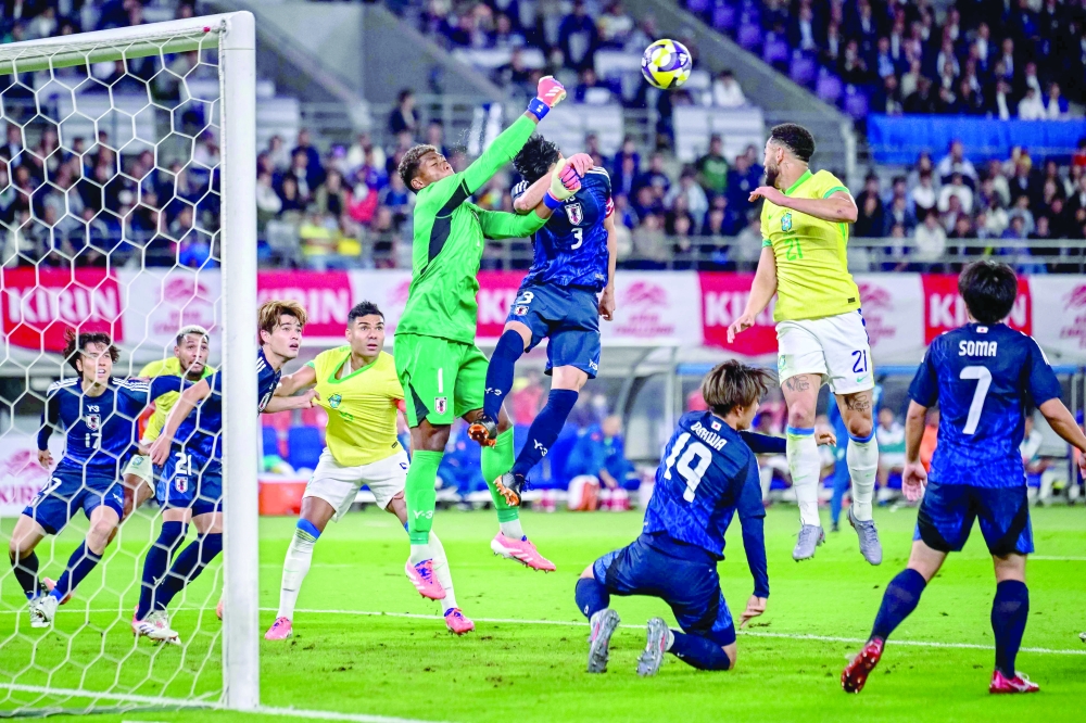 Japan goalkeeper Zion Suzuki (centre L) makes a save during the international football friendly match between Japan and Brazil at the Tokyo stadium in Chofu, Tokyo prefecture on October 14, 2025.  (Photo by Yuichi YAMAZAKI / AFP)
