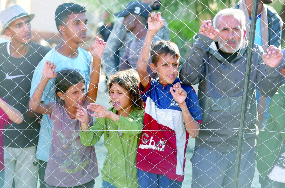 People watch as a truck carrying the bodies of Palestinians who had been held in Israel during the war arrives at Nasser hospital on Tuesday. - Reuters