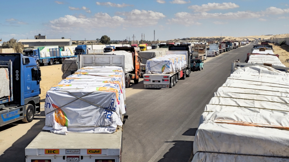 Trucks carrying humanitarian aid prepared by the Egyptian Red Crescent line up in Al-Arish