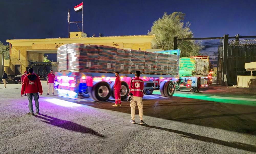 Trucks carrying aid bound for Gaza cross the border crossing between Egypt and the Gaza Strip