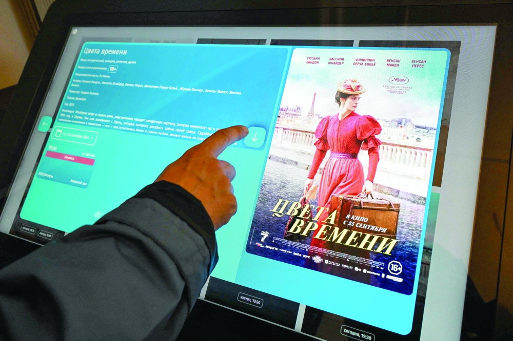 A person uses an electronic system for tickets for a screening of French director Cedric Klapisch's dramatic comedy La venue de l'avenir at a cinema in Moscow. — AFP