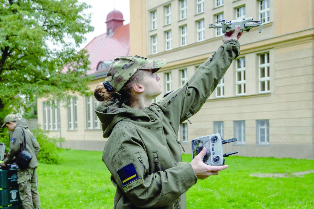 Aleksandra Kaszczuk at the Legnica Military High School flies a drone in front of the school building in Legnica, western Poland. — AFP