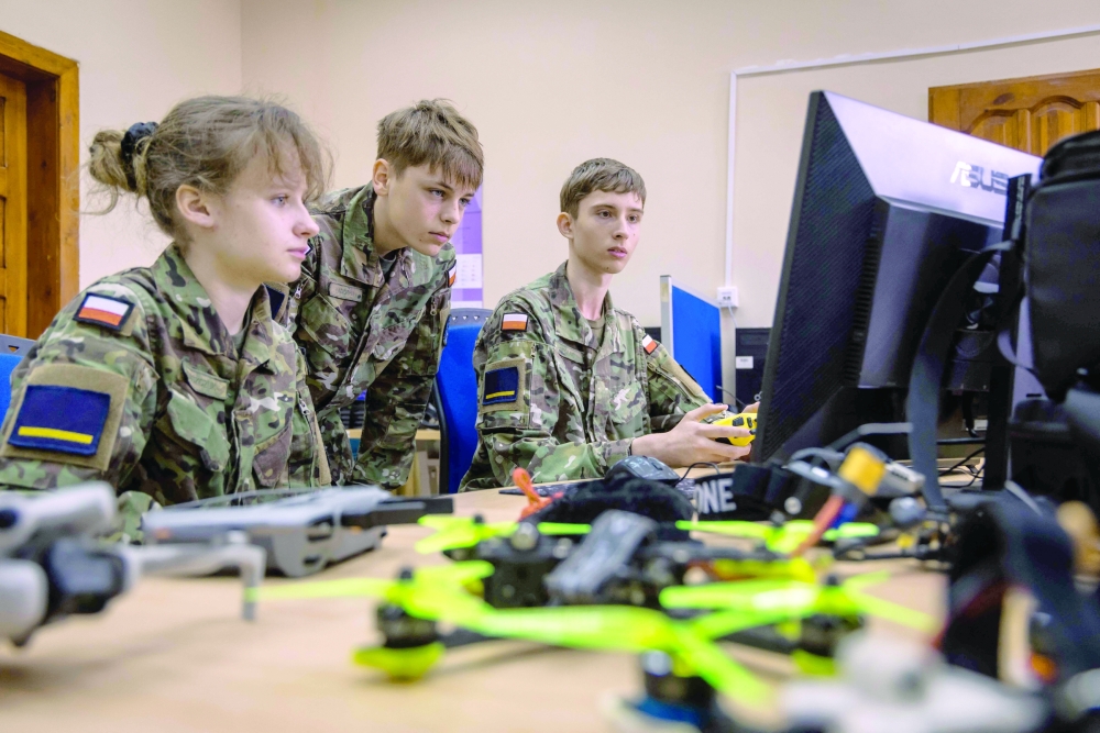Students look at a drone simulator in the computer classroom of the school. — AFP