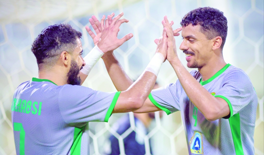 Al Nahda players celebrate after a goal.