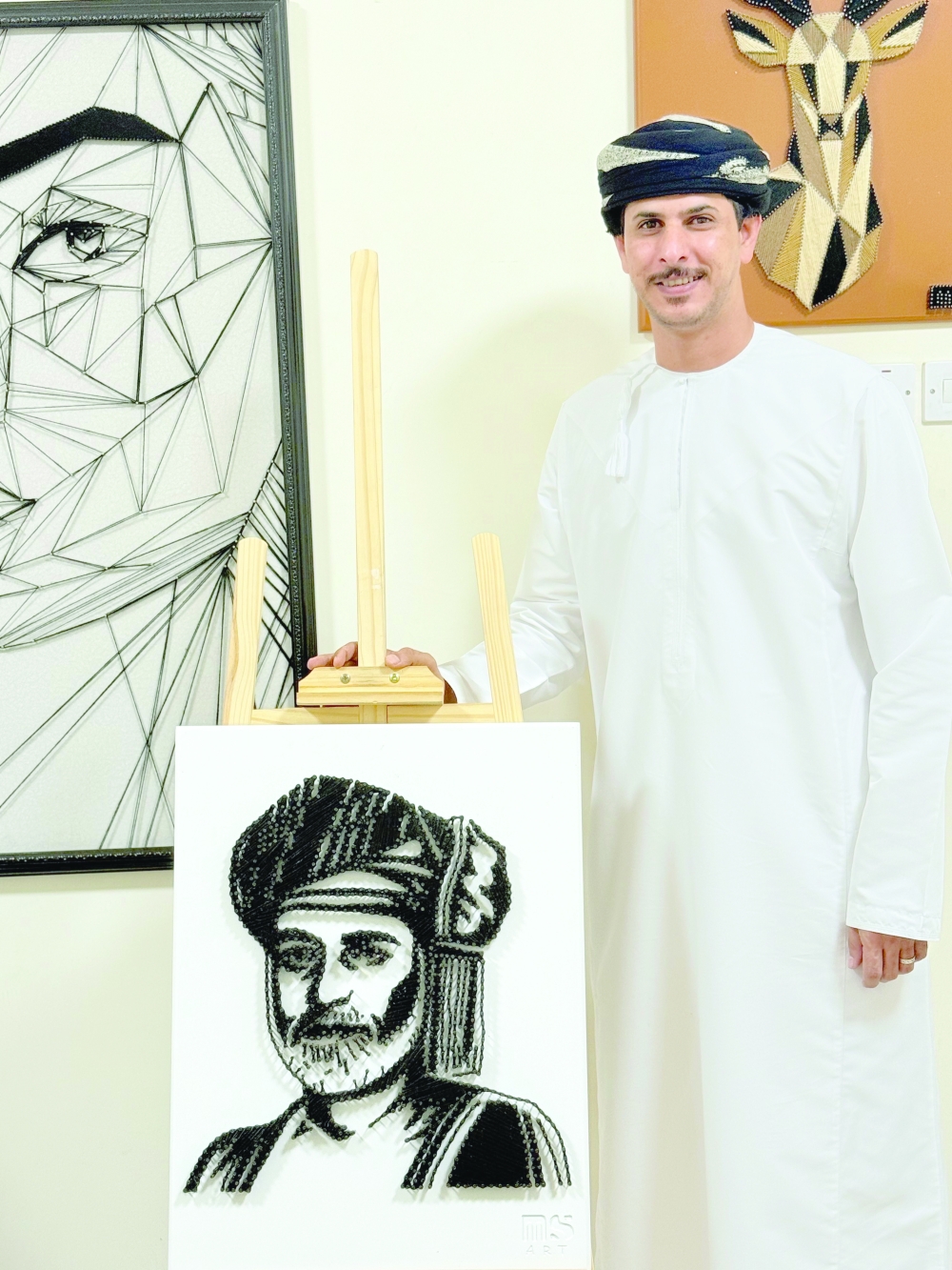 Mazen Said Ali al Quraini with his portrait of the late His Majesty Sultan Qaboos