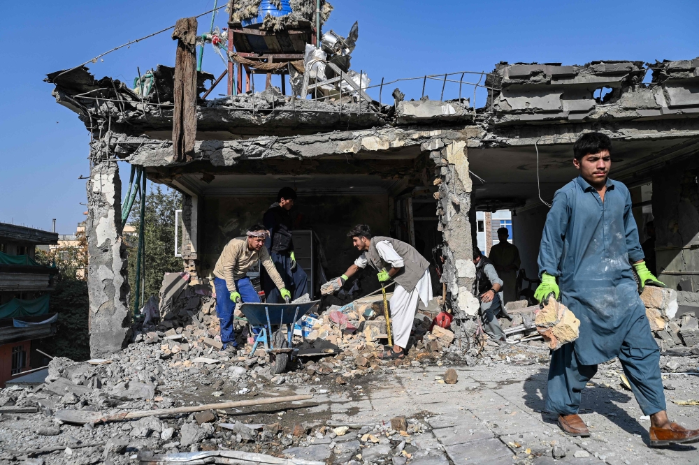 Afghan workers remove debris from a house, in Kabul. — AFP