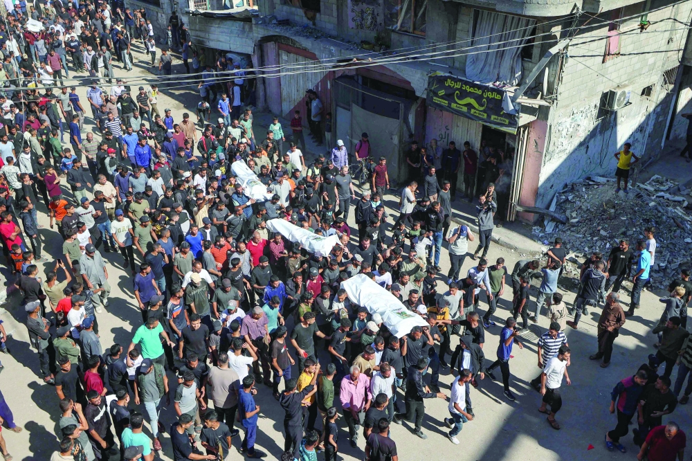 People carry the bodies of Palestinians released by Israel under a Gaza ceasefire and hostage exchange, during their funeral in the Bureij refugee camp in the central Gaza Strip on Saturday. — AFP