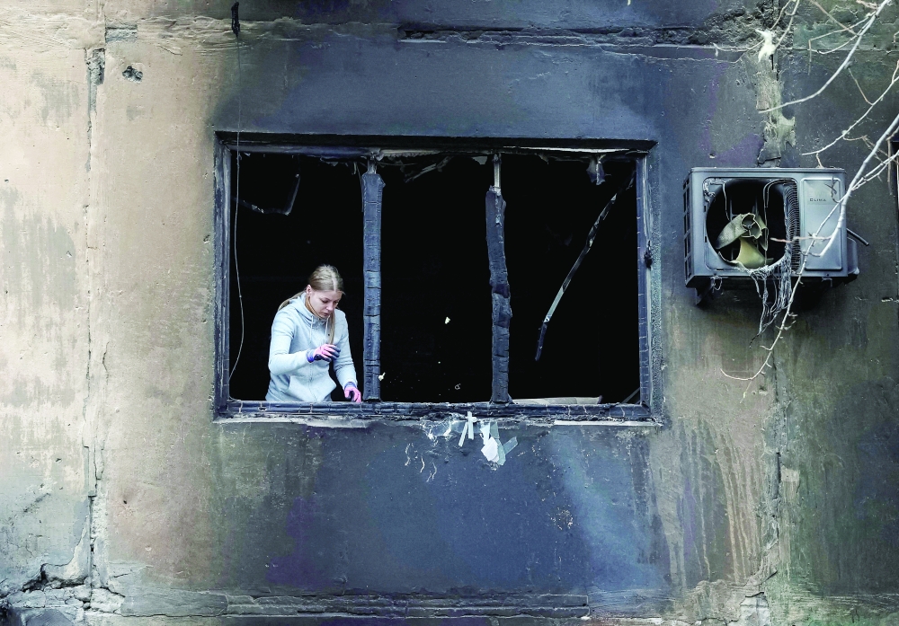 A resident removes broken glass damaged by a Russian drone strike, in the town of Shakhtarske in Dnipropetrovsk region, Ukraine. — Reuters