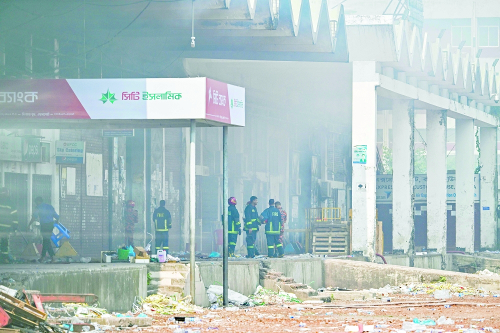 Firefighters inspect the fire-damaged cargo terminal of Hazrat Shahjalal International Airport in Dhaka. — AFP