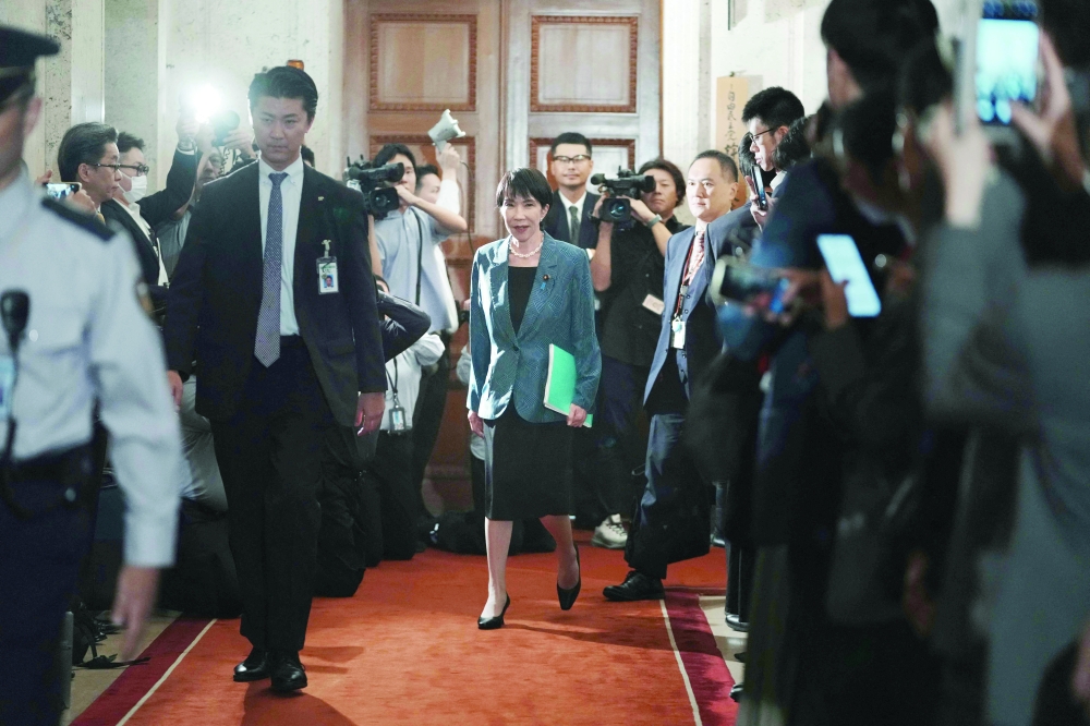 Japan's Liberal Democratic Party (LDP) President Sanae Takaichi (C) walks at the Diet, in Tokyo. — AFP