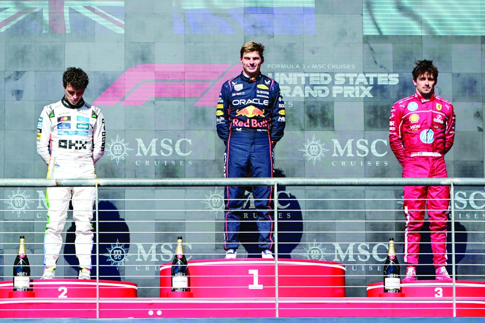 Race winner Red Bull Racing's Dutch driver Max Verstappen (C) stands alongside second place finisher McLaren's British driver Lando Norris (L) and third place finisher Ferrari's Monegasque driver Charles Leclerc (R) on the podium after the United States Formula One Grand Prix at the Circuit of the Americas in Austin, Texas. — AFP
