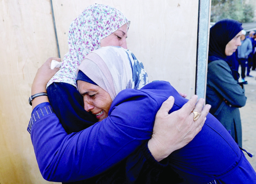 
Mourners react as they attend the funeral of Palestinians killed in Sunday’s Israeli strikes in the central Gaza Strip on Monday. — Reuters 
