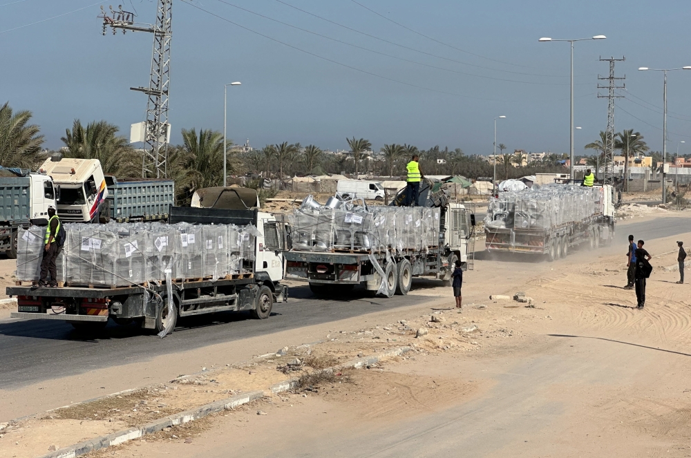 Trucks carry aid for Palestinians, amid a ceasefire between Israel and Hamas, in Deir Al-Balah