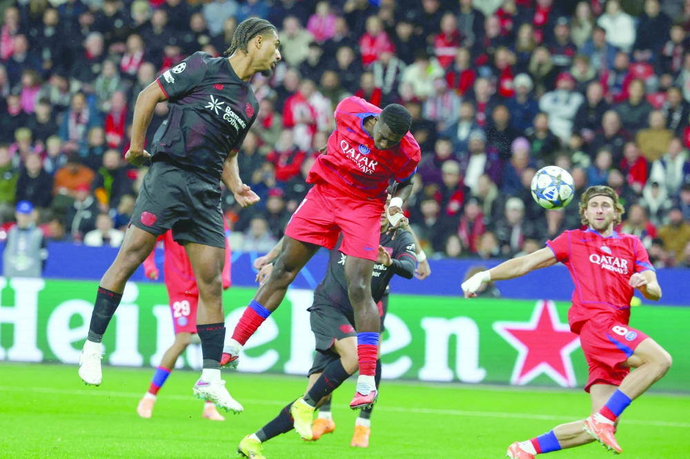 Paris Saint-Germain's Ecuadoran defender #51 Willian Pacho (C) scores the opening goal next to Bayer Leverkusen's French defender #05 Loic Bade (L) during the UEFA Champions League football match. — AFP 