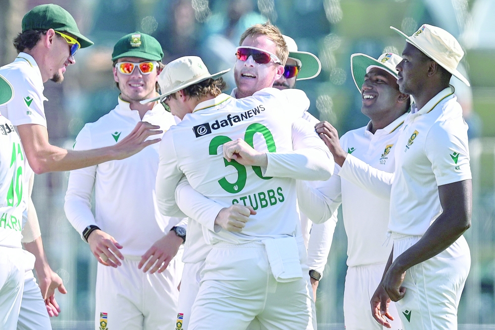 South Africa's Simon Harmer (3R) celebrates with teammates after taking the wicekt of Pakistan's Babar Azam during the fourth day of the second Test cricket match between Pakistan and South Africa at the Rawalpindi Cricket Stadium in Rawalpindi on October 23, 2025.  (Photo by Aamir QURESHI / AFP)
